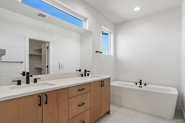 5604 Grandville Ave, Longmont, CO 80503 - full bath featuring a sink, visible vents, a freestanding bath, and double vanity