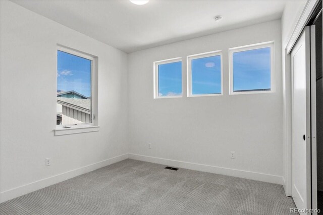 5604 Grandville Ave, Longmont, CO 80503 - unfurnished bedroom with baseboards, multiple windows, and light carpet