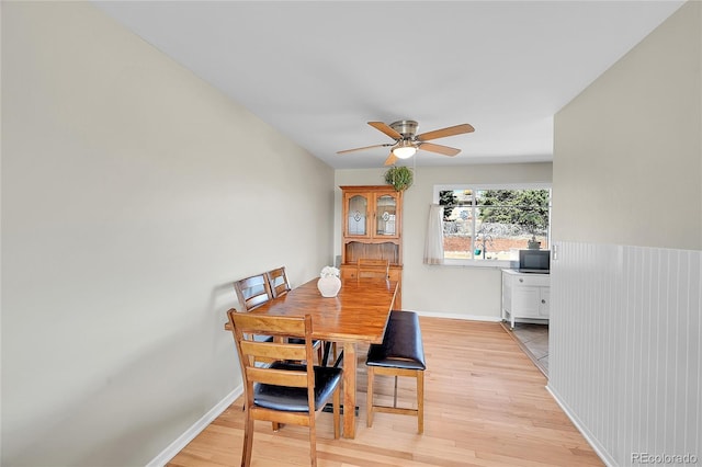 dining space with light wood-type flooring, ceiling fan, and baseboards