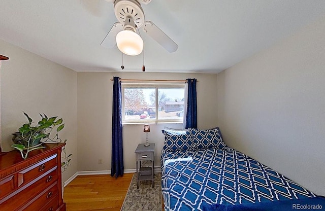 bedroom with wood finished floors, a ceiling fan, and baseboards