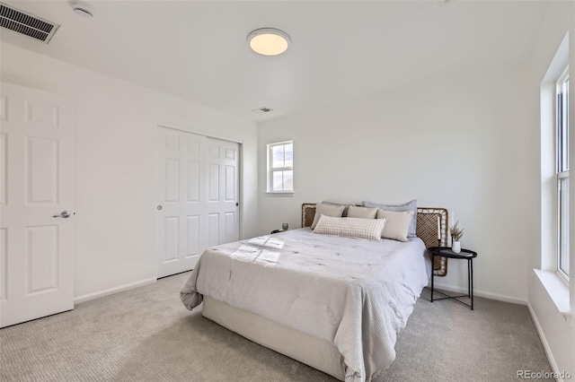 bedroom featuring a closet and light colored carpet