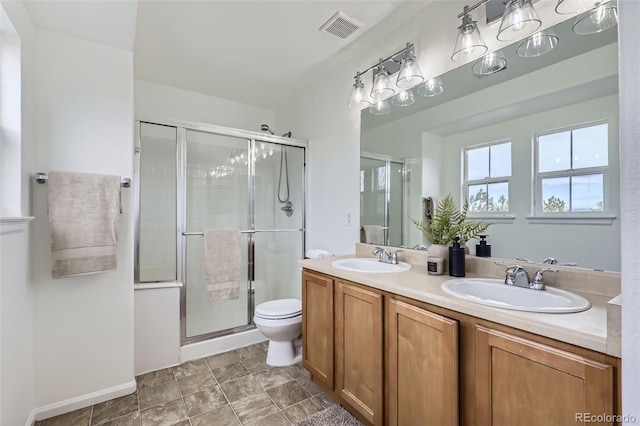 bathroom featuring a shower with shower door, toilet, and vanity