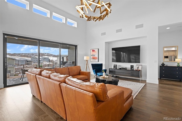 living room featuring plenty of natural light, dark wood-type flooring, and a chandelier