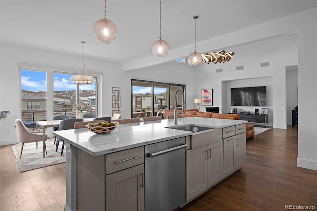 kitchen featuring a kitchen island with sink, sink, gray cabinets, and stainless steel dishwasher