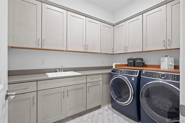 laundry room featuring cabinets, separate washer and dryer, and sink