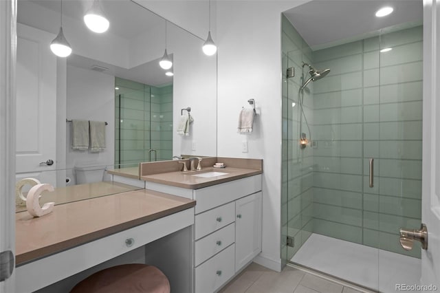 bathroom featuring tile patterned floors, vanity, and a shower with door