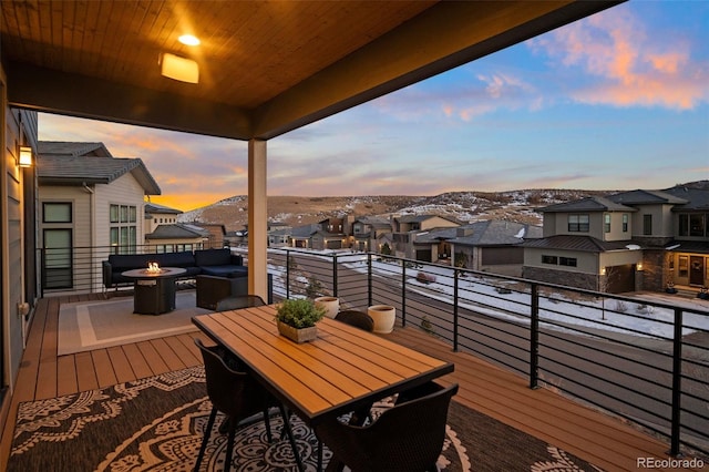 balcony at dusk featuring an outdoor fire pit