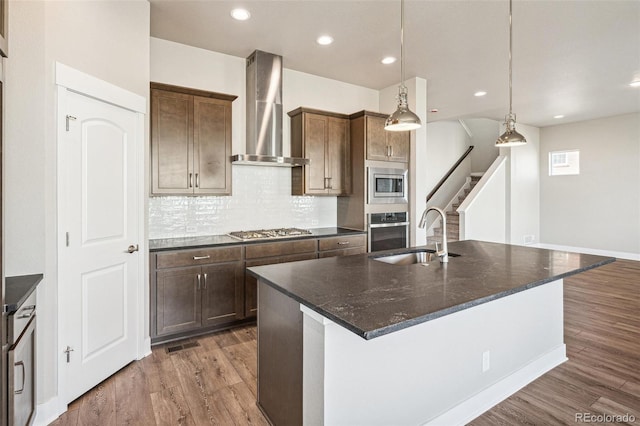 21295 E 61st Dr, Aurora, CO 80019 - kitchen featuring wood finished floors, wall chimney range hood, stainless steel appliances, and a sink