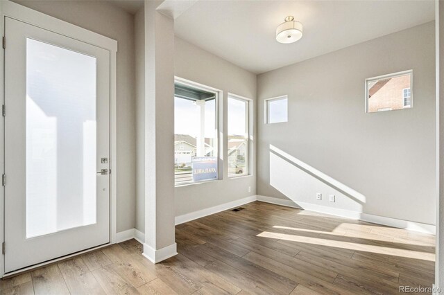 21295 E 61st Dr, Aurora, CO 80019 - foyer entrance with baseboards, wood finished floors, and visible vents