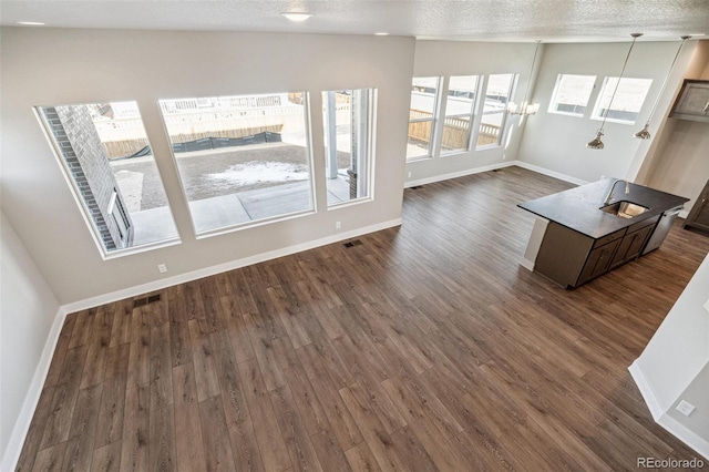 21295 E 61st Dr, Aurora, CO 80019 - living room with baseboards, dark wood-style flooring, a textured ceiling, and visible vents