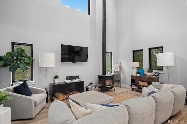 379 Rainbow Rd, Idaho Springs, CO 80452 - living area featuring a towering ceiling, a wood stove, wood finished floors, and baseboards
