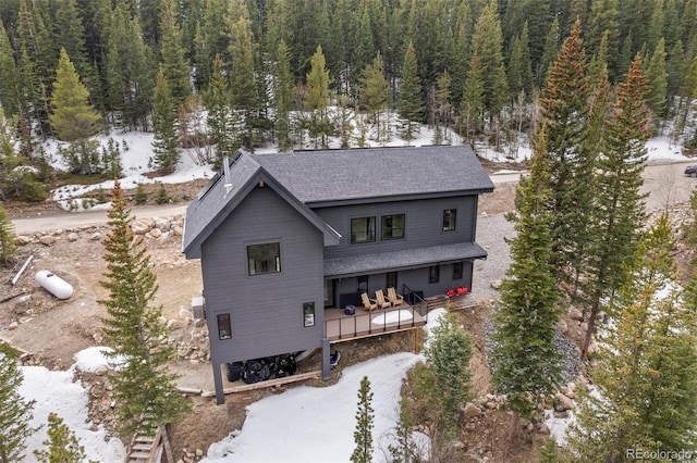 379 Rainbow Rd, Idaho Springs, CO 80452 - view of front facade with a view of trees, a deck, and roof with shingles