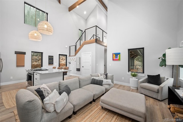 379 Rainbow Rd, Idaho Springs, CO 80452 - living room with high vaulted ceiling, beamed ceiling, baseboards, and light wood-style flooring