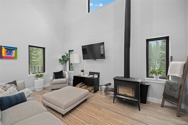 379 Rainbow Rd, Idaho Springs, CO 80452 - living area with a wood stove, a high ceiling, plenty of natural light, wood finished floors, and baseboards