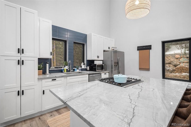 379 Rainbow Rd, Idaho Springs, CO 80452 - kitchen with appliances with stainless steel finishes, a towering ceiling, a sink, a center island, and white cabinetry
