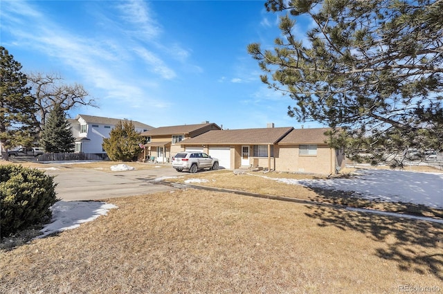 single story home featuring a garage and a front lawn