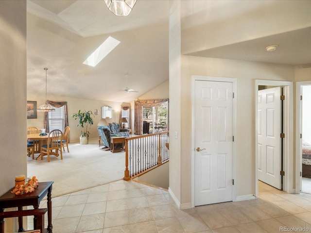 7158 W Belmont Dr, Littleton, CO 80123 - corridor with light carpet, baseboards, lofted ceiling with skylight, light tile patterned floors, and an upstairs landing