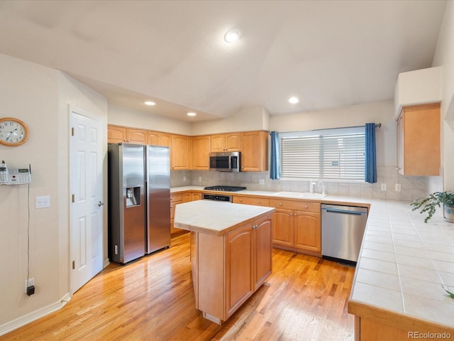 7158 W Belmont Dr, Littleton, CO 80123 - kitchen with light wood-type flooring, backsplash, stainless steel appliances, and tile countertops