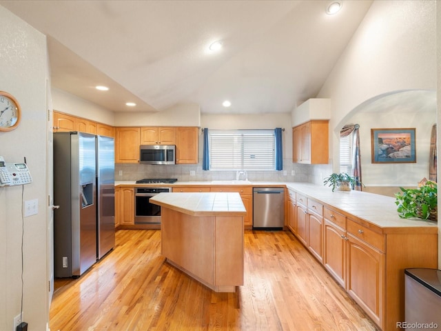 7158 W Belmont Dr, Littleton, CO 80123 - kitchen featuring stainless steel appliances, tile countertops, decorative backsplash, and vaulted ceiling
