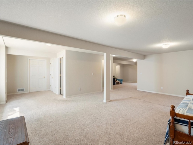 7158 W Belmont Dr, Littleton, CO 80123 - finished basement with baseboards, light colored carpet, a textured ceiling, and visible vents