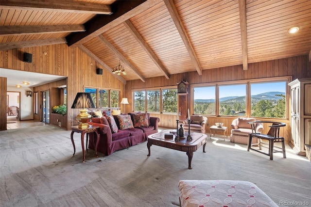 living area featuring wooden walls, a mountain view, and light colored carpet