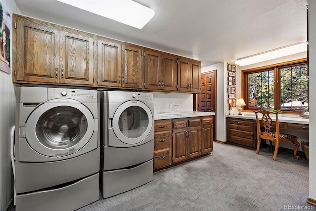 clothes washing area with light colored carpet, washing machine and dryer, cabinet space, and a sink