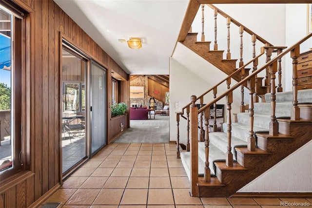 entrance foyer featuring stairway, tile patterned flooring, and wooden walls