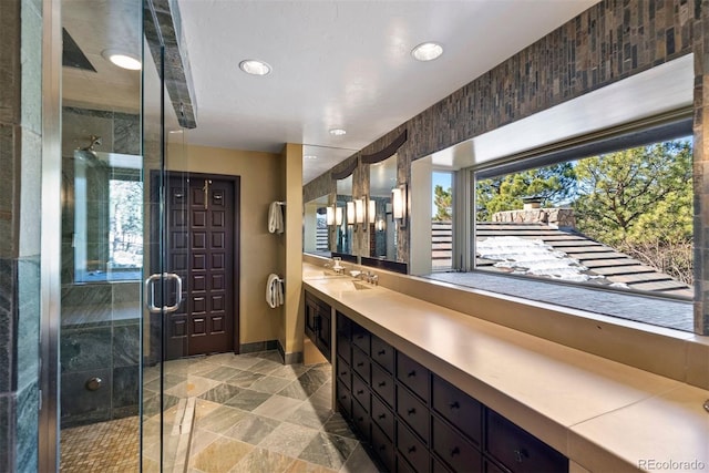 full bath featuring a stall shower, recessed lighting, baseboards, and vanity