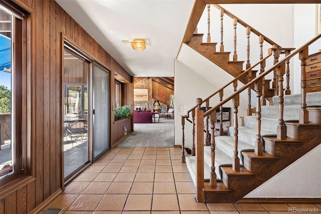 2851 Interlocken Dr, Evergreen, CO 80439 - foyer with wood walls, plenty of natural light, tile patterned flooring, and stairs