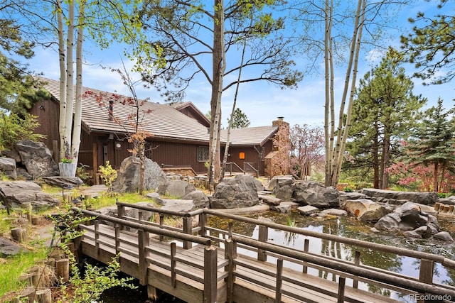 2851 Interlocken Dr, Evergreen, CO 80439 - back of property featuring a tiled roof, a chimney, and board and batten siding