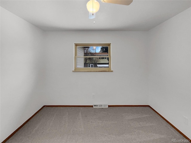 empty room with a ceiling fan, carpet flooring, visible vents, and baseboards