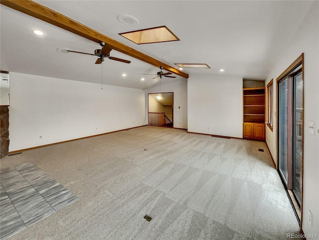 unfurnished living room with vaulted ceiling with skylight, light colored carpet, baseboards, and recessed lighting