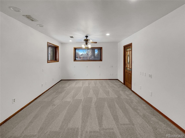 unfurnished room featuring a ceiling fan, light colored carpet, visible vents, and baseboards