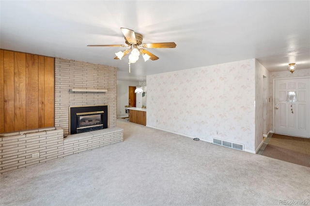 2043 Patrician Way, Colorado Springs, CO 80909 - unfurnished living room with carpet floors, a ceiling fan, and a brick fireplace