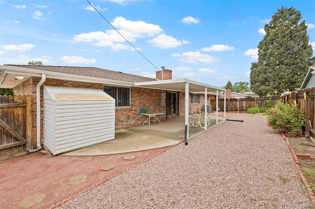 2043 Patrician Way, Colorado Springs, CO 80909 - rear view of property with a chimney, brick siding, a fenced backyard, and a patio
