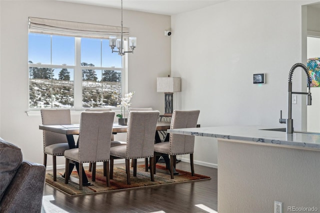 dining room with dark hardwood / wood-style flooring, a chandelier, and sink