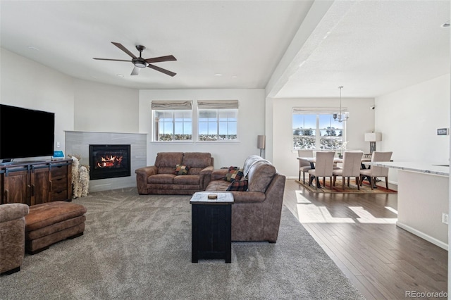 living room with wood-type flooring and ceiling fan with notable chandelier