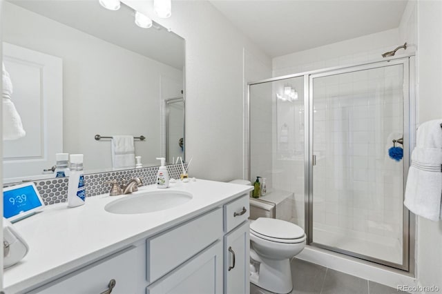 bathroom featuring tile patterned floors, vanity, toilet, and a shower with shower door