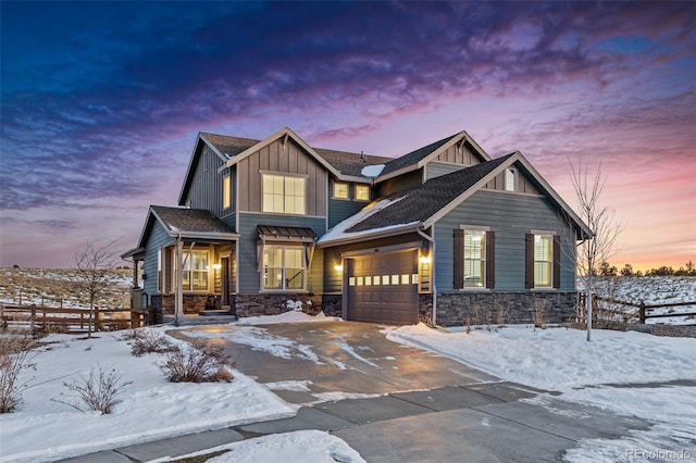 craftsman house with fence, board and batten siding, an attached garage, driveway, and stone siding