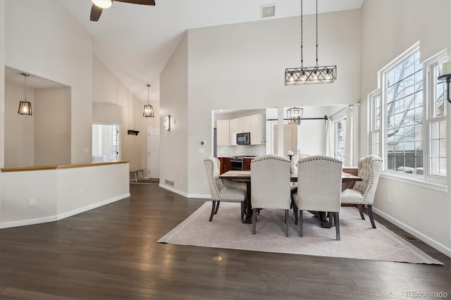 dining space with ceiling fan, high vaulted ceiling, and dark hardwood / wood-style floors