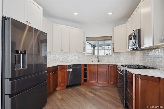 kitchen featuring hardwood / wood-style floors, decorative backsplash, sink, and stainless steel appliances