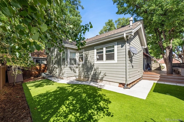 back of property featuring a yard and a wooden deck