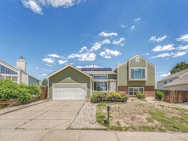778 S Fairplay Ct, Aurora, CO 80012 - tri-level home with brick siding, roof mounted solar panels, a garage, and concrete driveway
