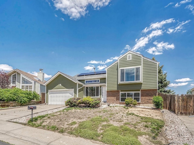 778 S Fairplay Ct, Aurora, CO 80012 - tri-level home featuring brick siding, solar panels, driveway, and a garage
