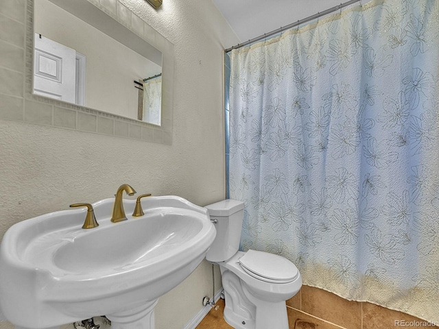 778 S Fairplay Ct, Aurora, CO 80012 - bathroom with a sink, toilet, tile patterned flooring, a shower with curtain, and a textured wall