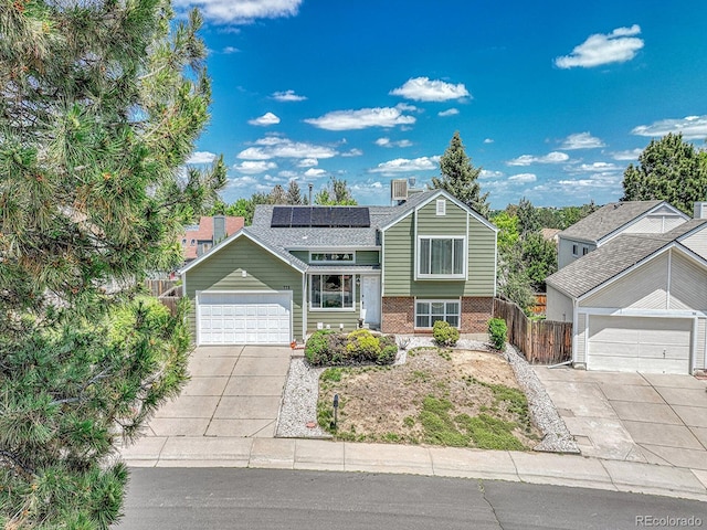 778 S Fairplay Ct, Aurora, CO 80012 - view of front of home featuring solar panels, brick siding, driveway, and a chimney