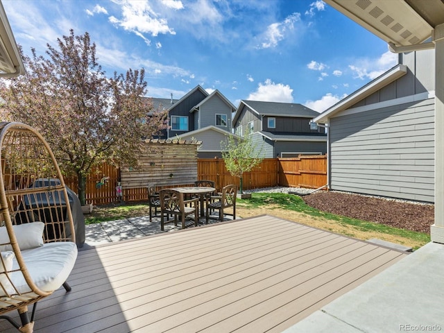 wooden terrace featuring a fenced backyard, a patio, and outdoor dining space