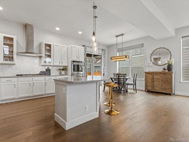 9378 E 60th Pl, Denver, CO 80238 - kitchen with decorative backsplash, wood finished floors, recessed lighting, wall chimney exhaust hood, and white cabinets