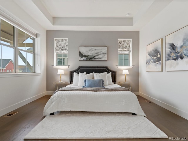 9378 E 60th Pl, Denver, CO 80238 - bedroom with baseboards, a tray ceiling, dark wood-style floors, and visible vents