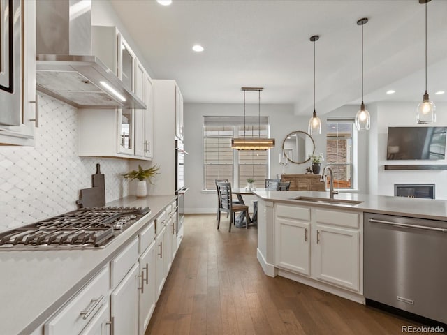 9378 E 60th Pl, Denver, CO 80238 - kitchen with wall chimney range hood, a sink, stainless steel appliances, white cabinetry, and decorative backsplash